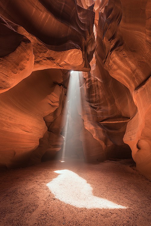 A fine art nature photograph of a beam of light illuminating antelope canyon, similar to Peter Lik's image by Bryce Mironuck