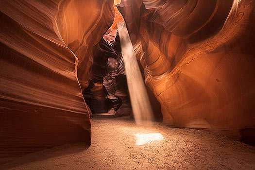 A nature photography print of a beam of light illuminating antelope canyon. Nature photography print by Bryce Mironuck