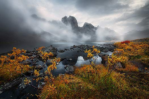 A nature photography print taken at Divide lake in Tombstone Territorial Park, Yukon. Photographed in fall, the clouds and fog surround the mountains. Nature photography print by Bryce Mironuck