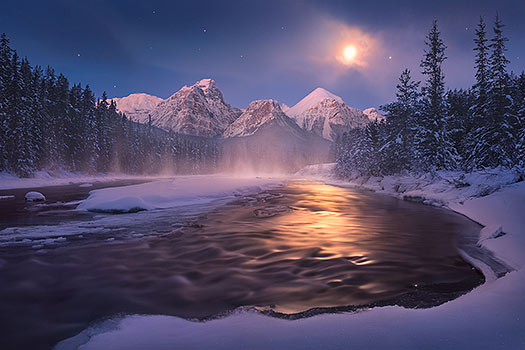 A nature photography print taken at morant's curve in Alberta as mist rises off of the water in the moonlight. A similar alternative to a Peter Lik image